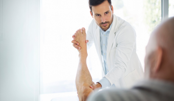 Doctor examining ankle popping when rotating
