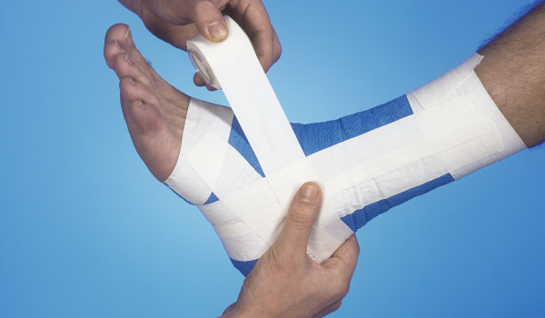 Foot being wrapped with athletic tape