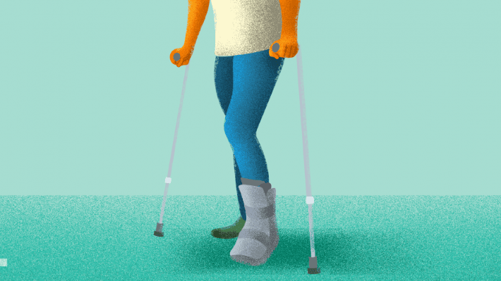Person walking with an ankle immobilizer and crutches due to an injured ankle