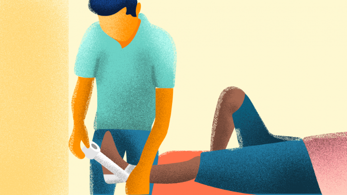 Physical therapist taping the sprained ankle of a patient